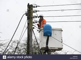 Electrician replacing mains overhead electricity cables for ...